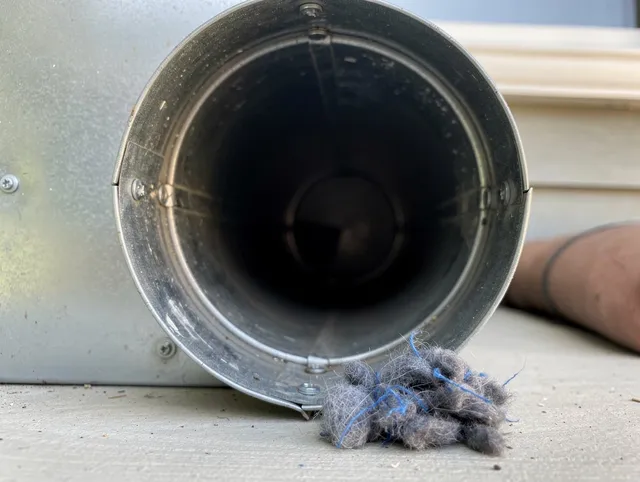 Warren Dryer Vent Cleaning technician using specialized equipment to clear severe dryer vent blockage in Warren